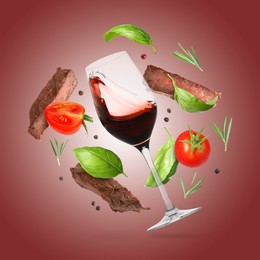 Image of Red wine in glass, grilled beef meat, tomatoes and spices falling on maroon gradient background