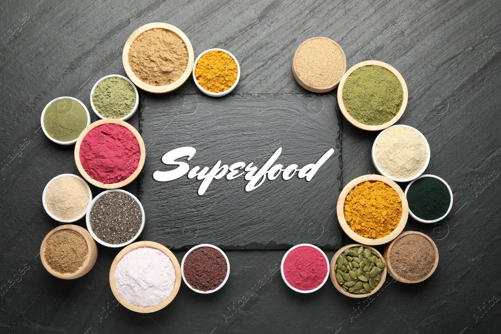 Superfood. Different powders and products in bowls on black table, flat lay Image of Superfood. Different powders and products in bowls on black table, flat lay