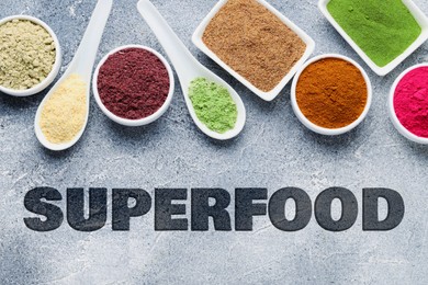 Image of Superfood. Different powders in bowls and spoons on grey table, flat lay