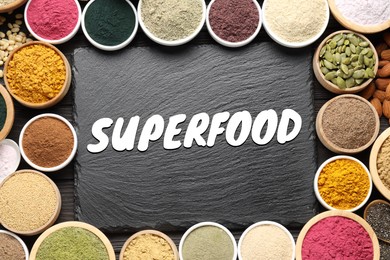 Image of Superfood. Different powders, food products and slate board on wooden table, flat lay