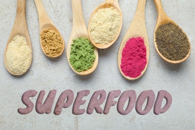 Image of Superfood. Different powders in spoons on grey table, flat lay