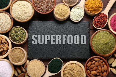 Image of Superfood. Different powders, food products and slate board on wooden table, flat lay