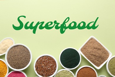 Image of Different superfoods in bowls on light green background, flat lay