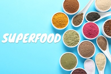 Image of Superfood. Different powders in bowls and spoons on light blue background, flat lay