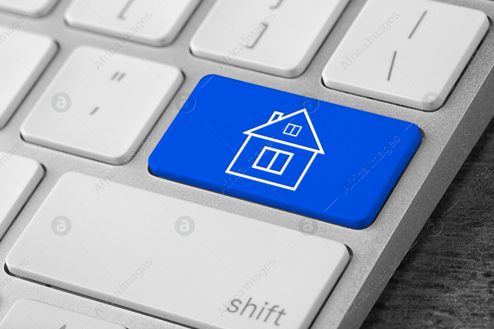 Image of Online accommodation search. Button with house icon on computer keyboard, closeup