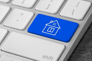 Image of Online accommodation search. Button with house icon on computer keyboard, closeup