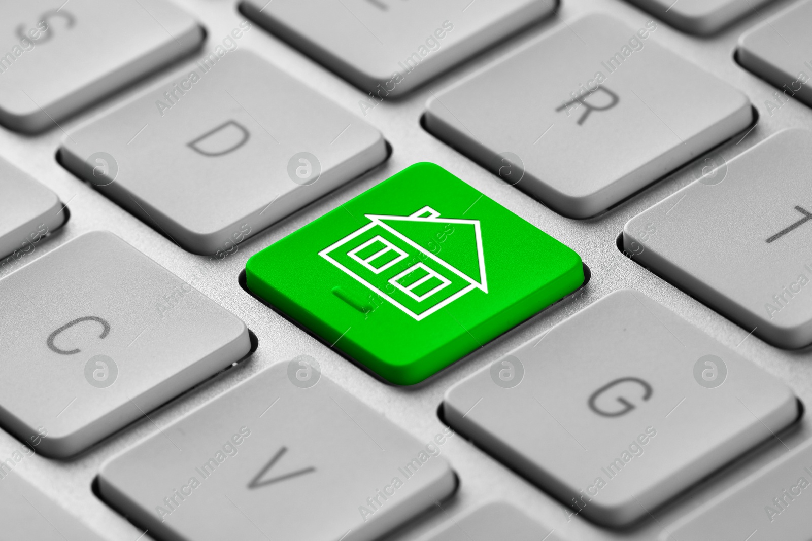 Image of Online accommodation search. Button with house icon on computer keyboard, closeup