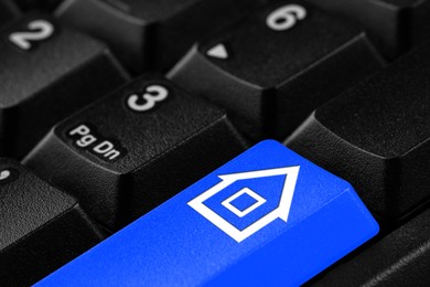 Image of Online accommodation search. Button with house icon on computer keyboard, closeup