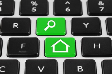 Image of Online accommodation search. Buttons with house and magnifying glass icons on computer keyboard, closeup