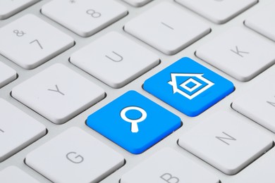 Image of Online accommodation search. Buttons with house and magnifying glass icons on computer keyboard, closeup