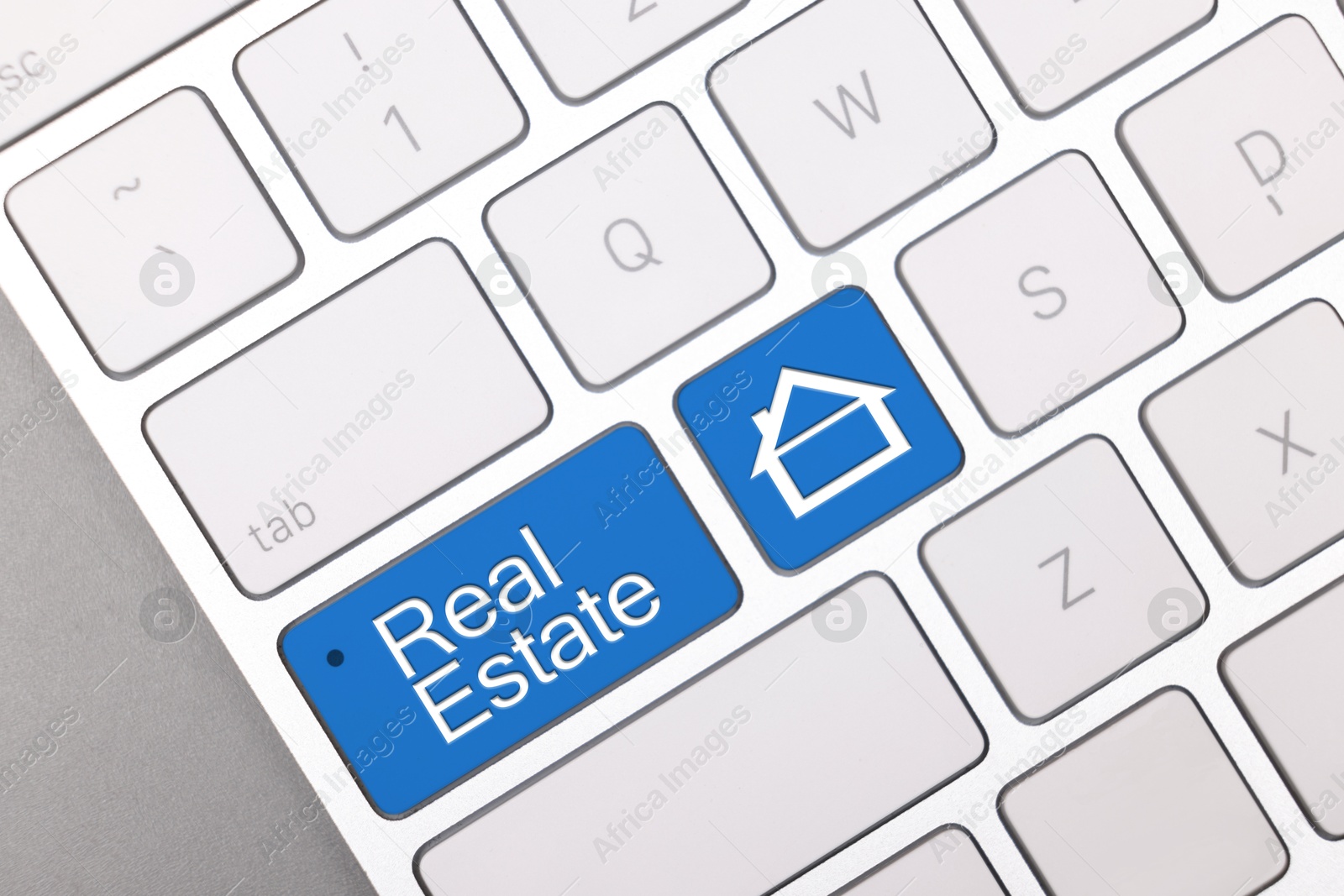 Online accommodation search. Buttons with house icon and words Real Estate on computer keyboard, closeup Image of Online accommodation search. Buttons with house icon and words Real Estate on computer keyboard, closeup