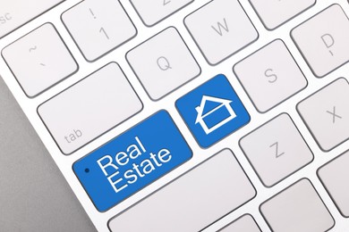 Image of Online accommodation search. Buttons with house icon and words Real Estate on computer keyboard, closeup