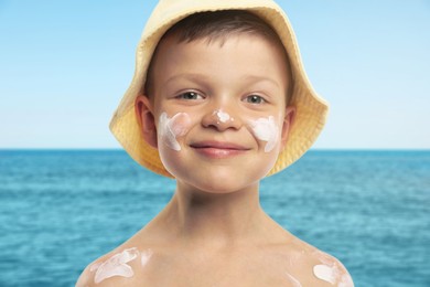 Image of Little boy with sunscreen on his skin at beach. Sun protection while outdoor recreation in summer
