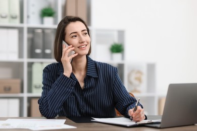Photo of Beautiful woman talking on phone at desk in office. Space for text