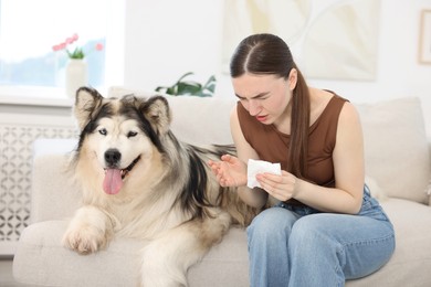 Photo of Woman suffering from allergy with her dog at home