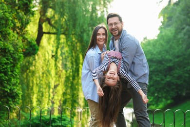 Photo of Family portrait of smiling parents and daughter in park. Space for text