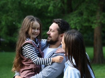Photo of Happy parents and their daughter in park