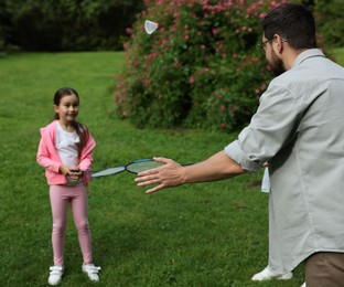 Photo of Family getaway. Father playing badminton with his daughter outdoors, selective focus