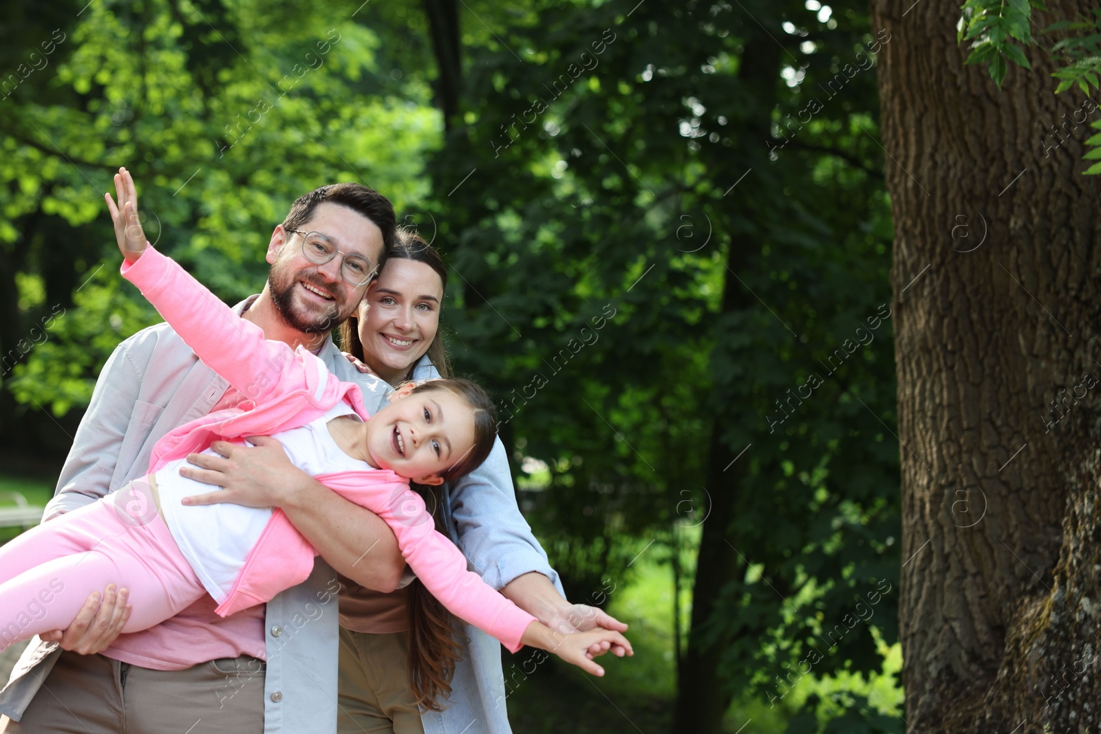 Family portrait of smiling parents and daughter outdoors Photo of Family portrait of smiling parents and daughter outdoors