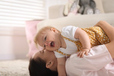 Photo of Mother and her little baby on floor at home