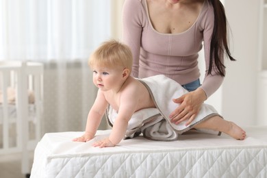 Photo of Mother with her cute baby at home, closeup