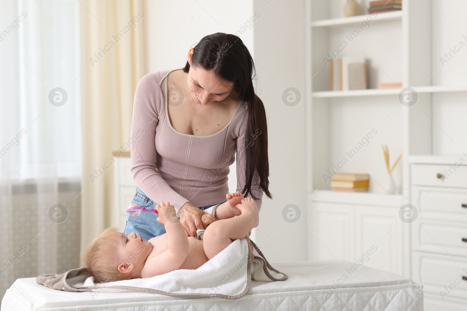 Mother with her cute baby at home, space for text Photo of Mother with her cute baby at home, space for text