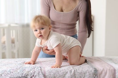 Photo of Mother with her cute baby at home, closeup