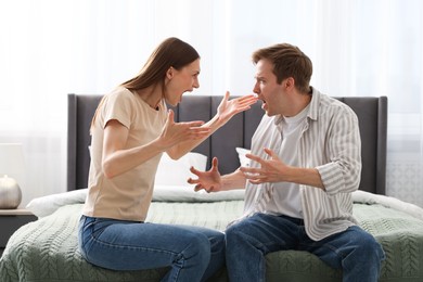 Photo of Woman and man fighting on bed at home