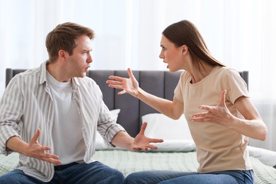 Photo of Woman and man fighting on bed at home