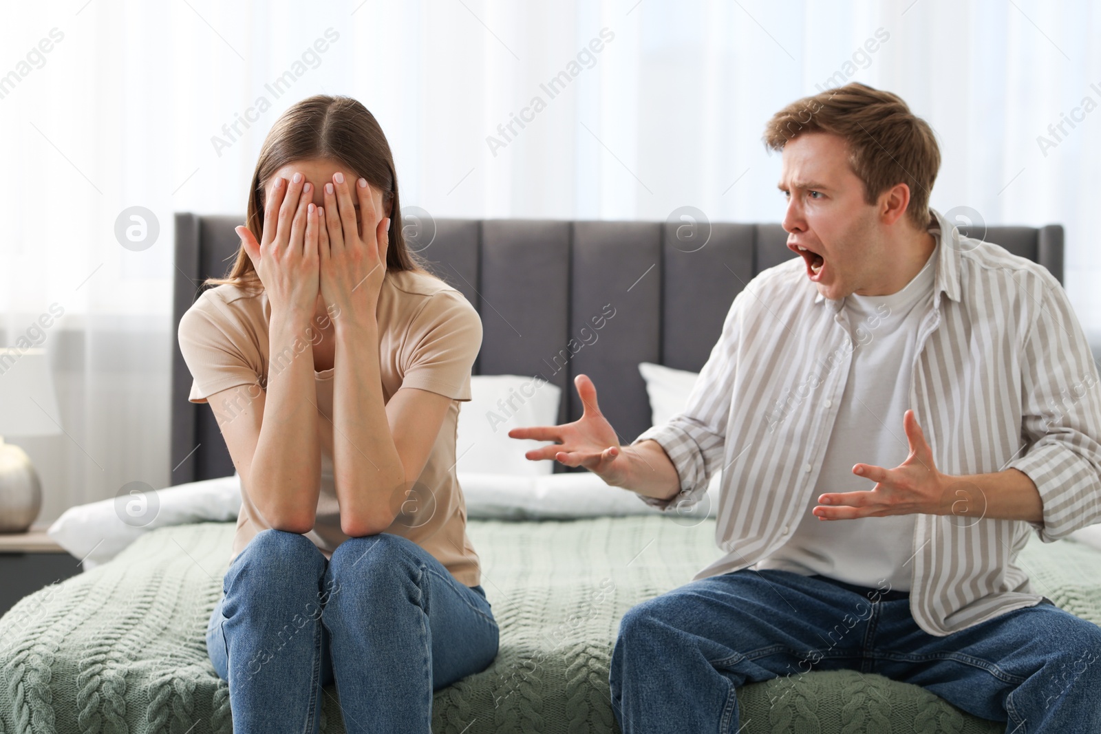 Woman and man fighting on bed at home Photo of Woman and man fighting on bed at home