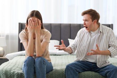 Photo of Woman and man fighting on bed at home
