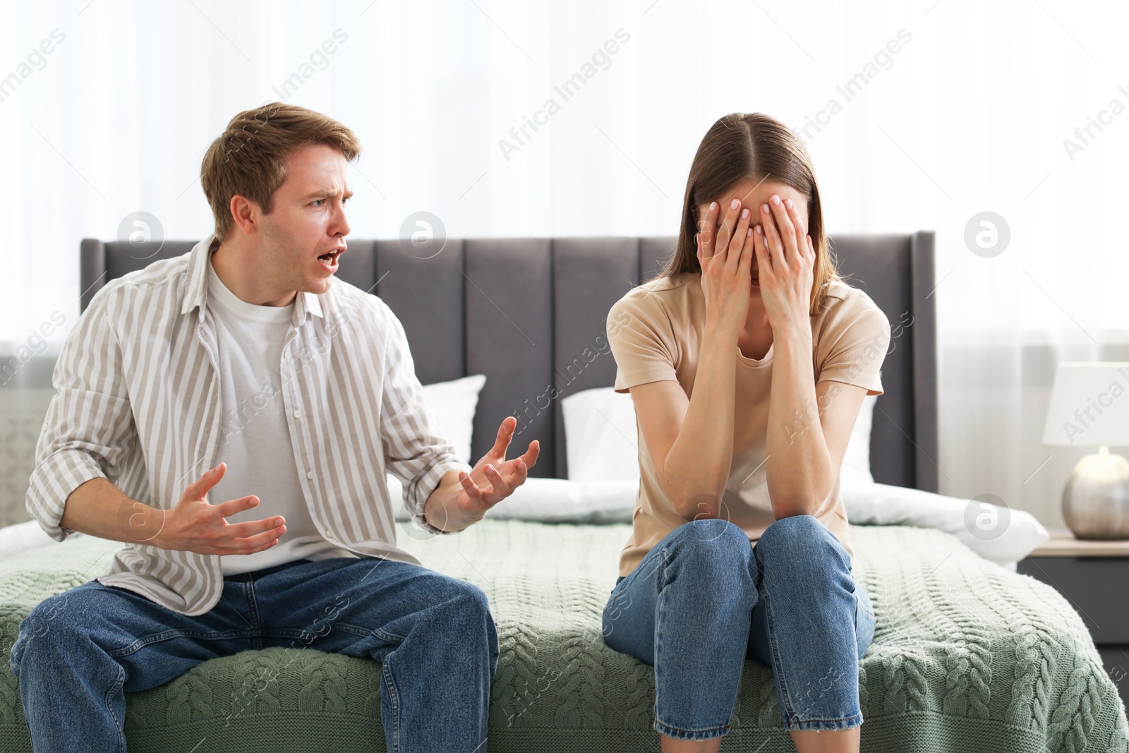 Woman and man fighting on bed at home Photo of Woman and man fighting on bed at home