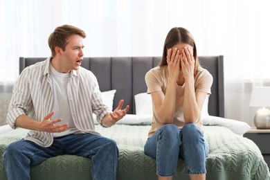 Photo of Woman and man fighting on bed at home