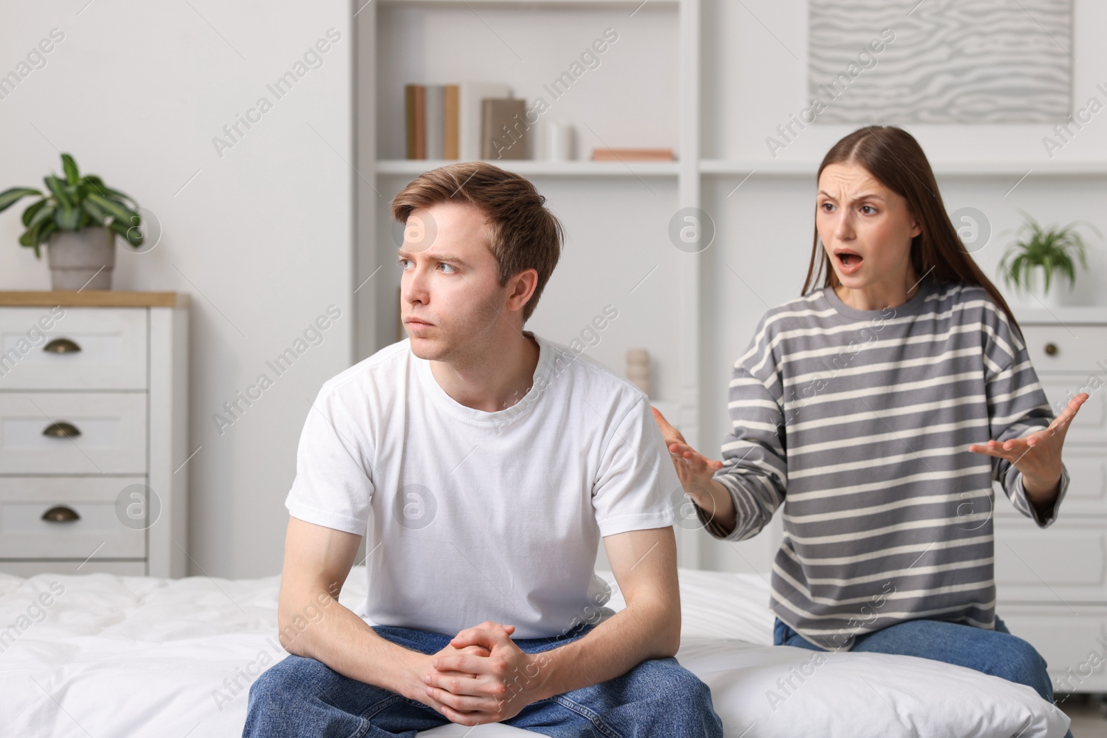 Woman and man fighting on bed at home Photo of Woman and man fighting on bed at home