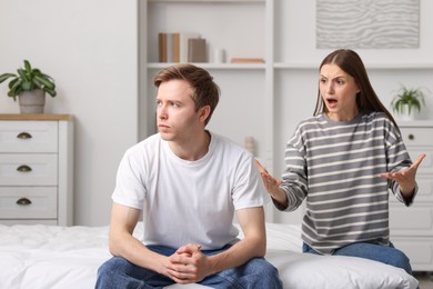 Photo of Woman and man fighting on bed at home