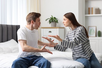 Photo of Woman and man fighting on bed at home