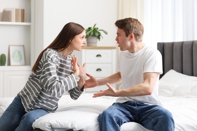 Photo of Woman and man fighting on bed at home