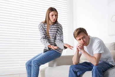 Photo of Woman and man having quarrel on sofa at home