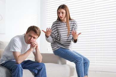 Photo of Woman and man having quarrel on sofa at home