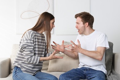 Photo of Woman and man having quarrel on sofa at home