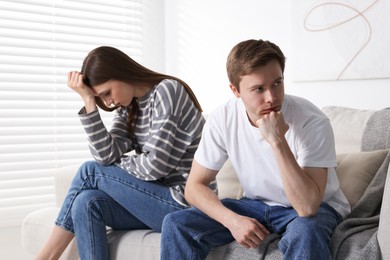 Photo of Woman and man having quarrel on sofa at home