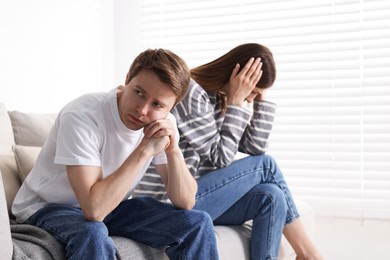 Photo of Woman and man having quarrel on sofa at home