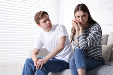 Photo of Woman and man having quarrel on sofa at home