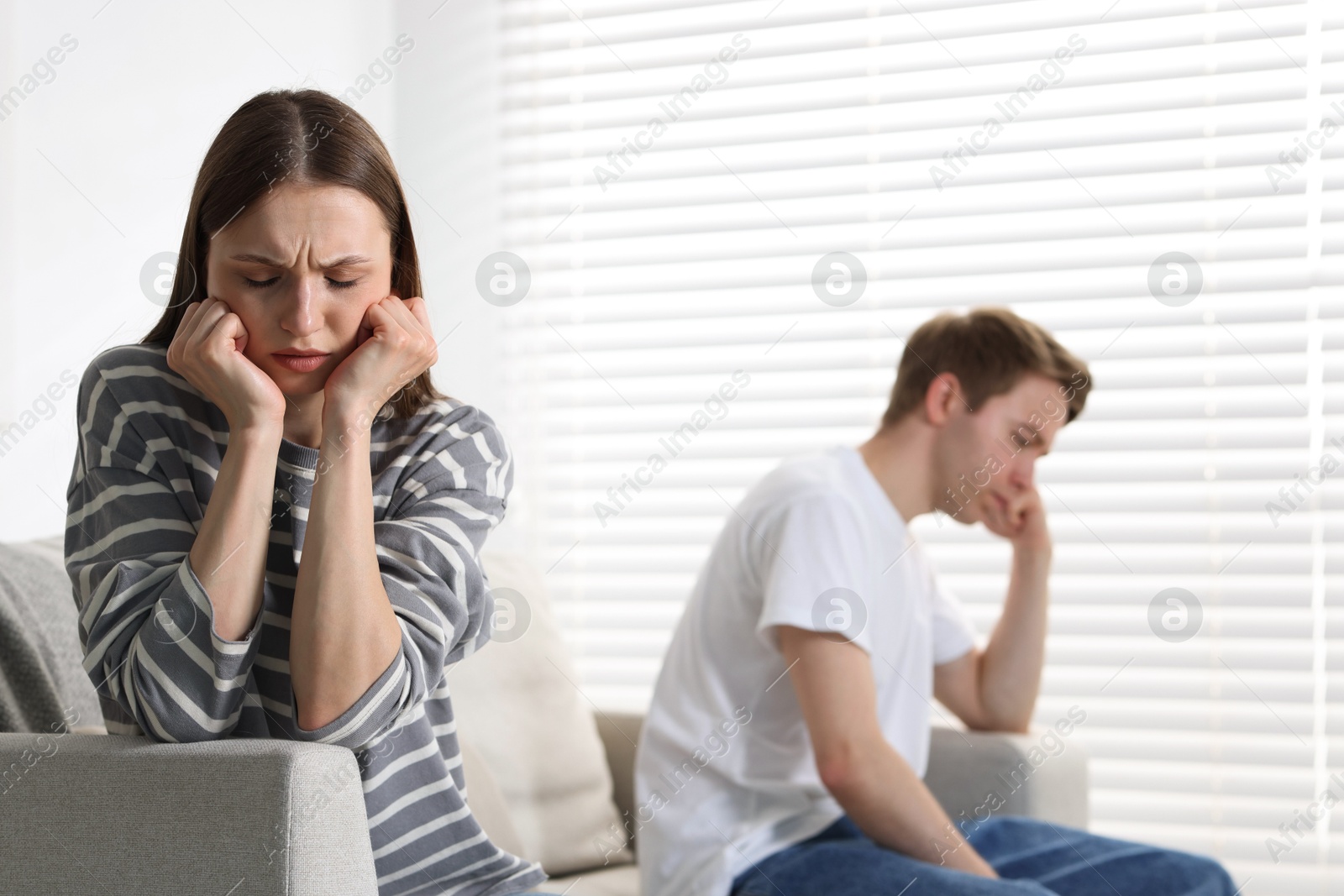 Woman and man having quarrel on sofa at home, selective focus Photo of Woman and man having quarrel on sofa at home, selective focus