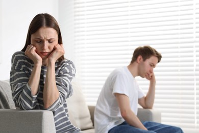 Photo of Woman and man having quarrel on sofa at home, selective focus