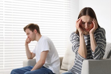 Photo of Woman and man having quarrel on sofa at home, selective focus