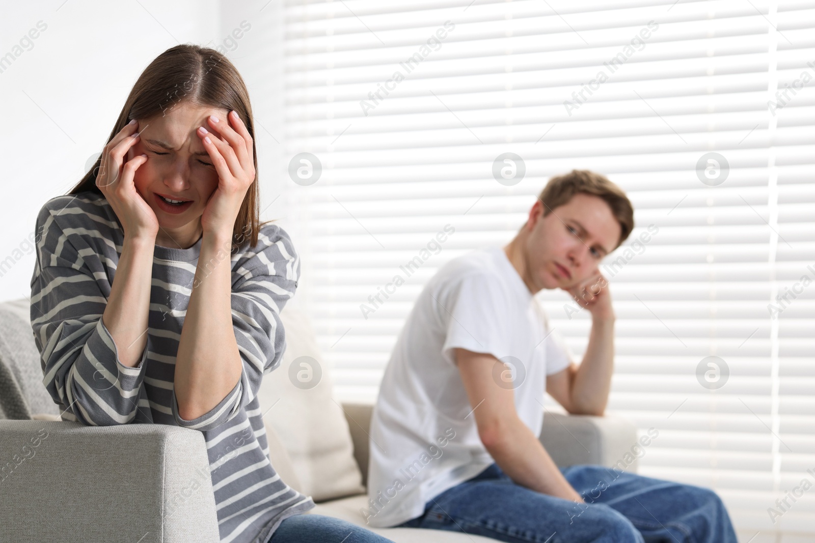 Woman and man having quarrel on sofa at home, selective focus Photo of Woman and man having quarrel on sofa at home, selective focus