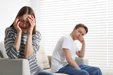 Photo of Woman and man having quarrel on sofa at home, selective focus