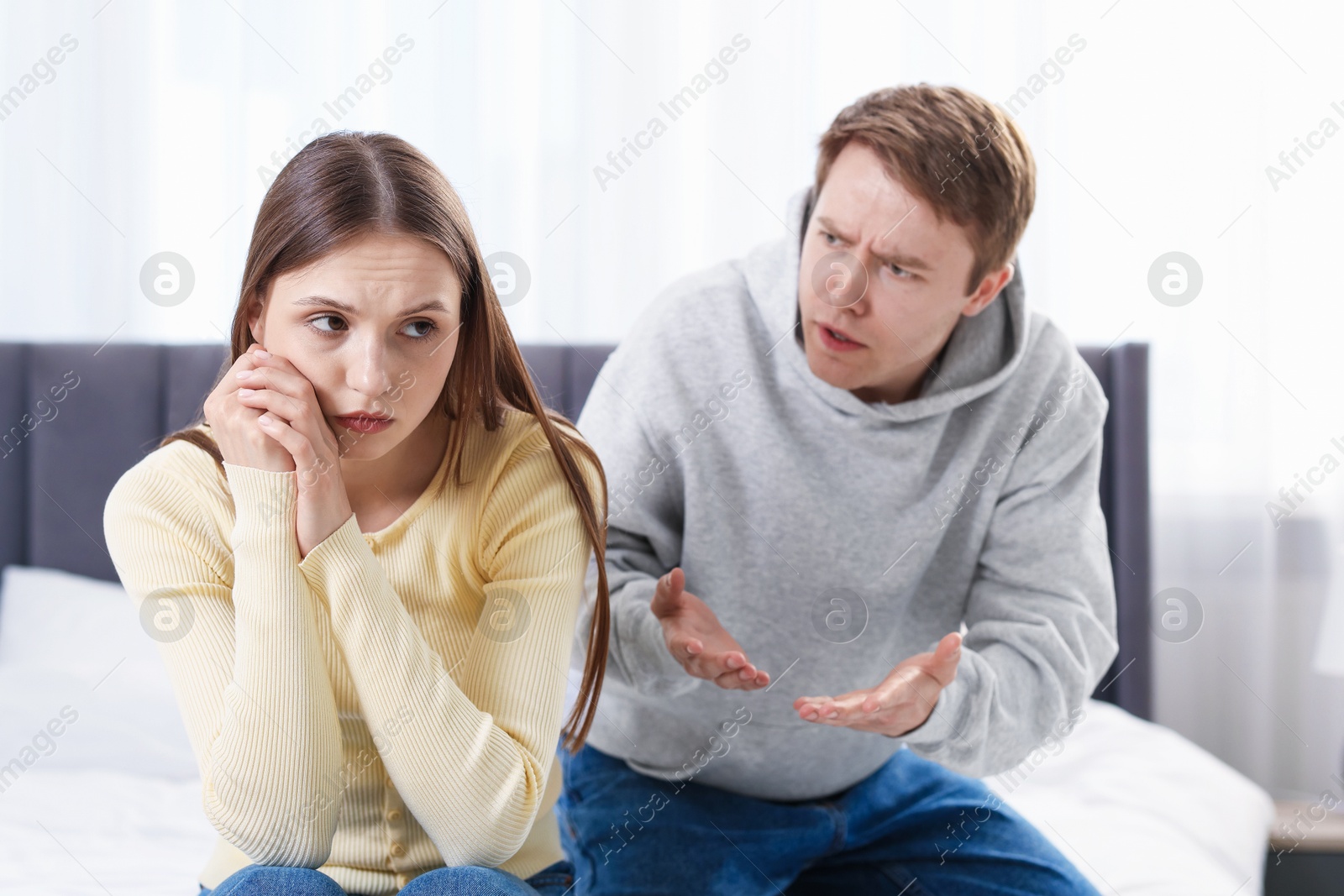 Photo of Woman and man having quarrel on bed at home