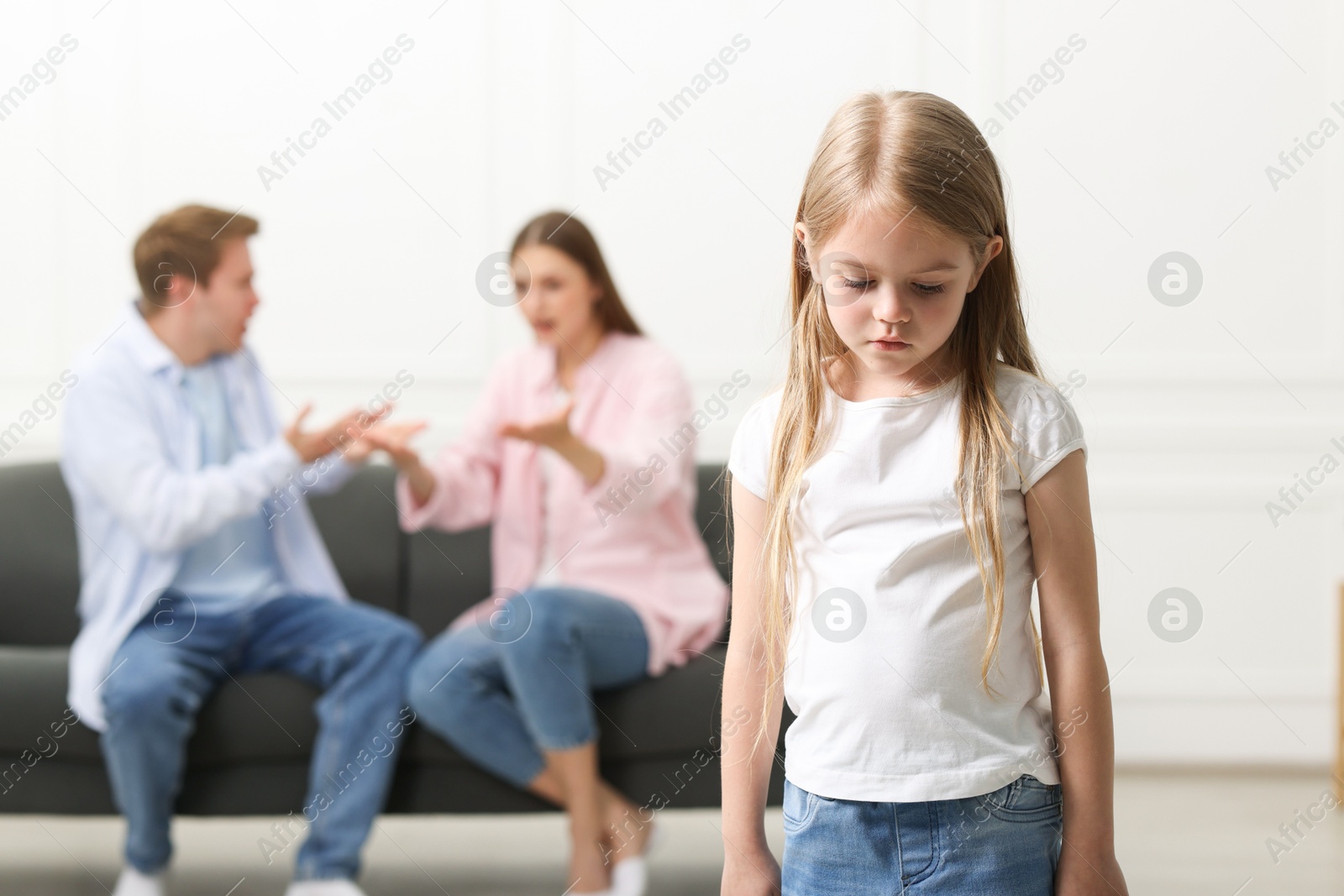 Upset little girl and her parents fighting at home, selective focus Photo of Upset little girl and her parents fighting at home, selective focus
